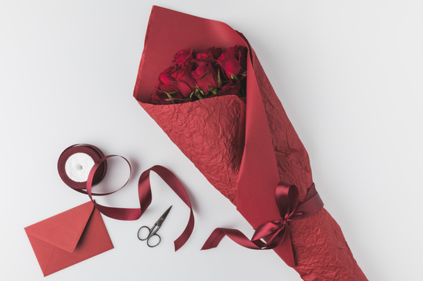flat lay with bouquet of roses, ribbon and envelope isolated on white, st valentines day holiday concept - Photo, Image