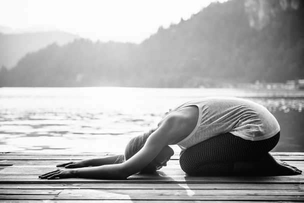 Donna in bambino che pratica yoga sul lago
 - Foto, immagini