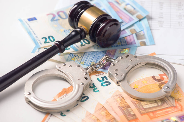 Гевель, наручники з євро гроші. Концепція злочину та шахрайства
 - Фото, зображення