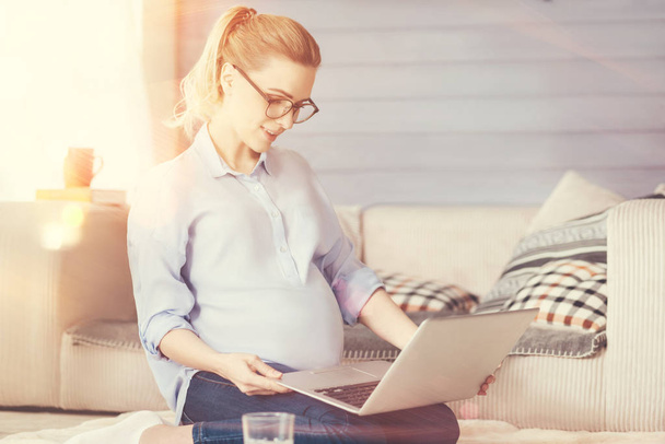 Delighted pregnant woman using laptop - Fotó, kép