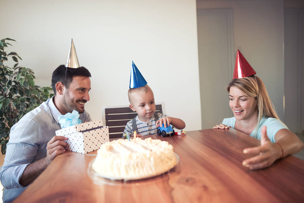 Celebración, familia, vacaciones y cumpleaños concepto-mamá, papá e hijo regalo abierto
 - Foto, imagen