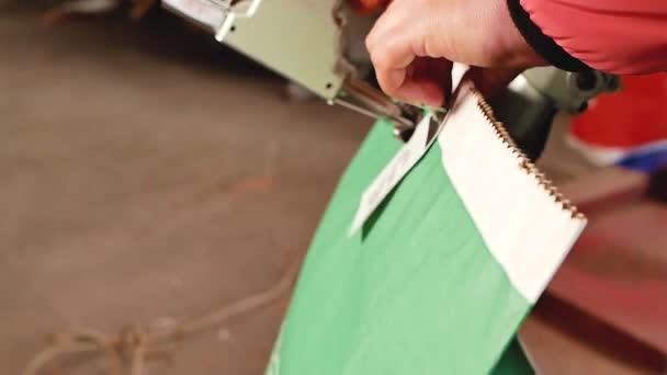 manos en guantes coser una insignia en la bolsa de maíz
 - Metraje, vídeo