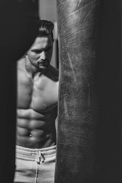 Muscular man with punching bag - Foto, Imagen