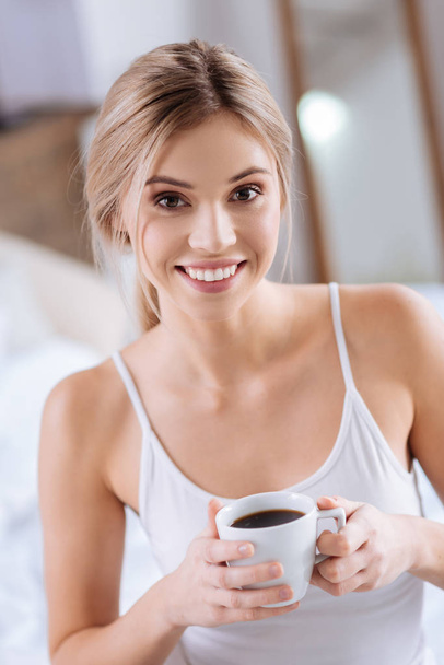 Portrait of smiling woman holding a cup of coffee - Zdjęcie, obraz
