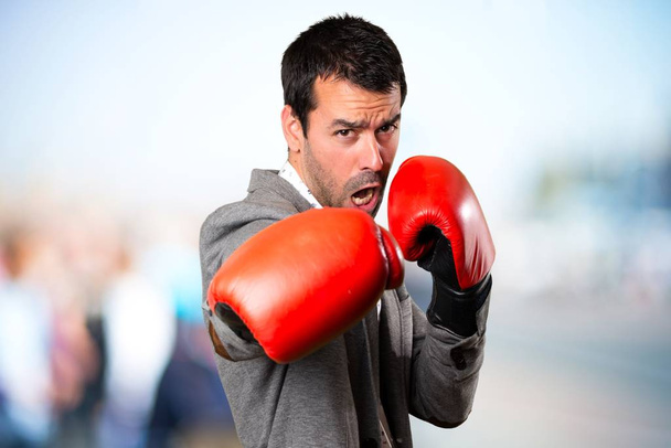 Handsome man with boxing gloves on unfocused background - Fotó, kép