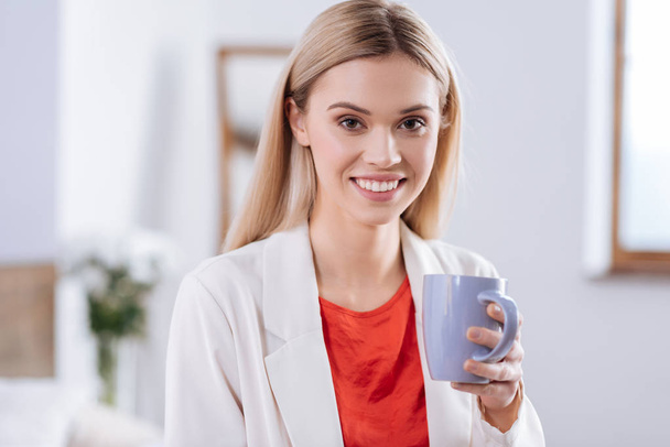 Cheerful woman in red blouse drinking coffee - Foto, immagini