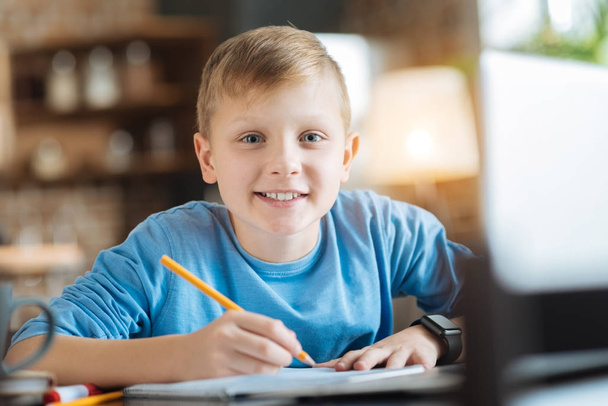 Cheerful delighted boy taking notes - Фото, изображение