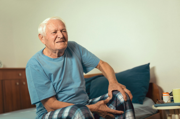 hombre mayor que sufre de dolor de osteoartritis en la rodilla
 - Foto, imagen