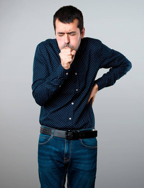 Handsome man coughing a lot on grey background - Photo, Image