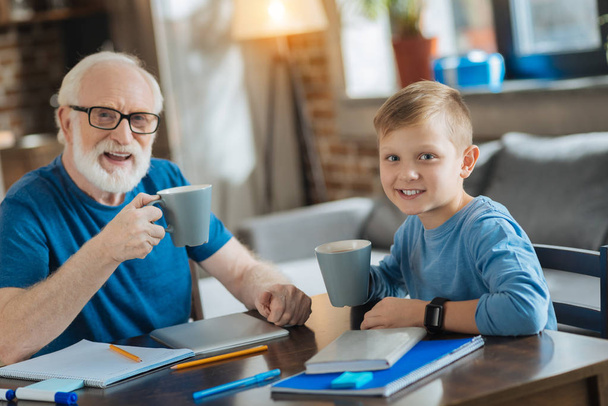 Happy positive boy having tea with his grandfather - Foto, immagini