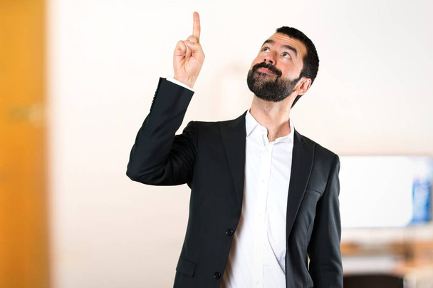 Handsome businessman pointing up in the office - Фото, изображение