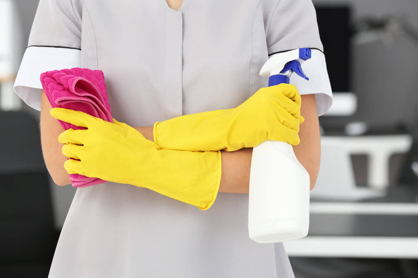 Woman with bottle of detergent and rag in office, closeup - Foto, Bild