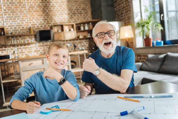Happy joyful grandfather and grandson showing their watches - Zdjęcie, obraz