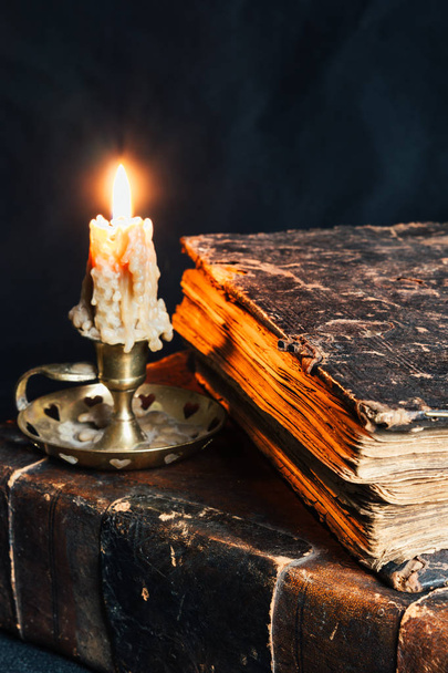 old closed books in leather cover with candle - Foto, afbeelding