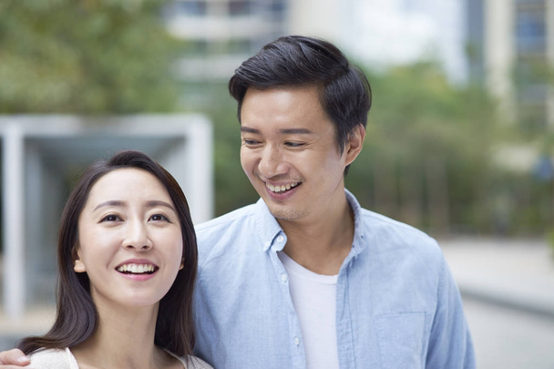 portrait of young Chinese couple standing & smiling outdoor  - Photo, Image