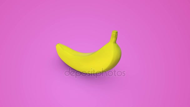 Rotación perfecta de un plátano amarillo sobre un fondo rosa
 - Metraje, vídeo