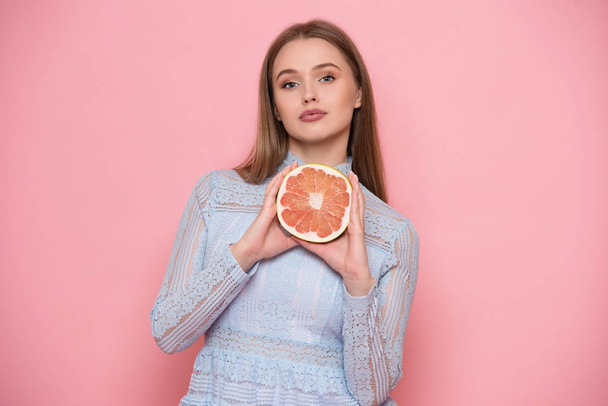 Žena ovoce dieta a zdravé potraviny jíst koncept. Dívka drží v rukou greapfruit. - Fotografie, Obrázek
