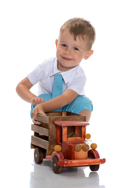 A little boy is playing with a toy car. - Fotó, kép