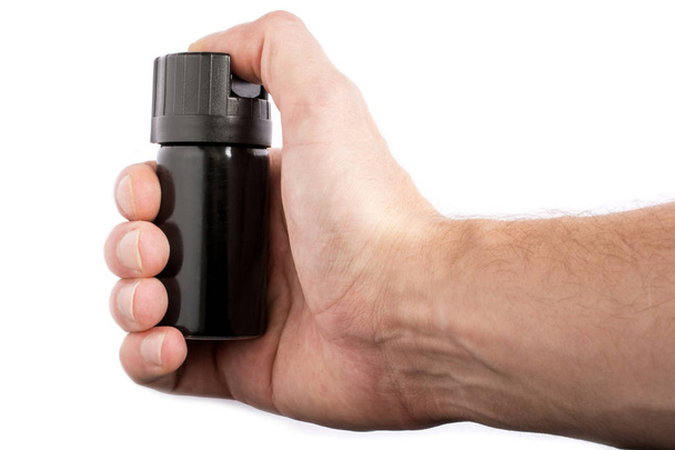 Hand with bottle of pepper spray isolated on white background - Photo, Image
