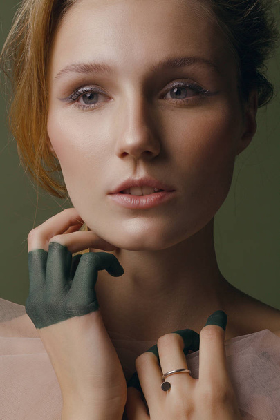 Menina bonita com maquiagem criativa e jóias prateadas em um fundo verde
 - Foto, Imagem