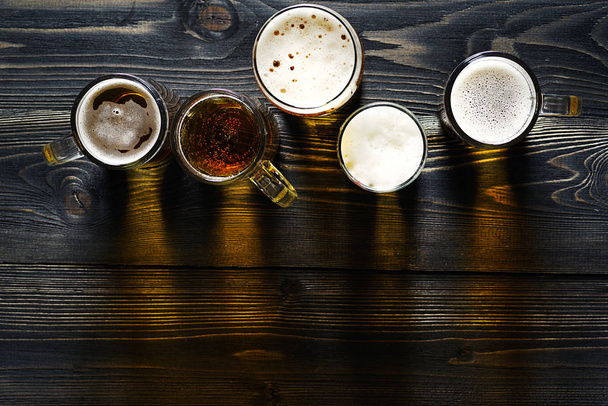 Lunettes de vue de dessus avec bière sur une table en bois sombre
. - Photo, image