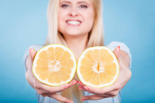 Woman holds grapefruit citrus fruit in hands - Valokuva, kuva