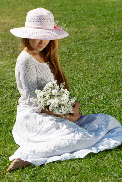 Girl in a hat with a bunch of flowers - 写真・画像
