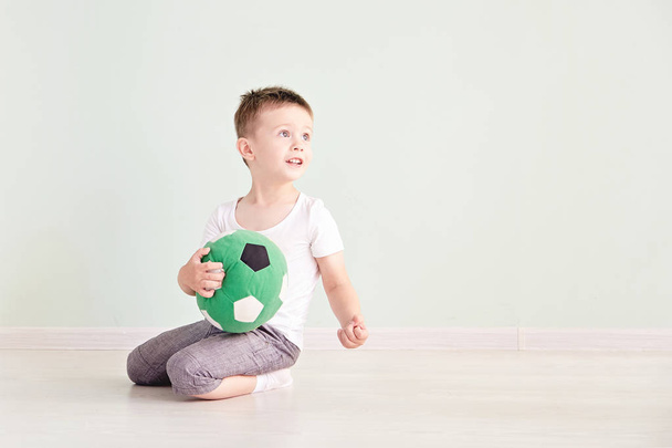 Full length portrait of a child with a soccer ball isolated in home - Foto, Imagem