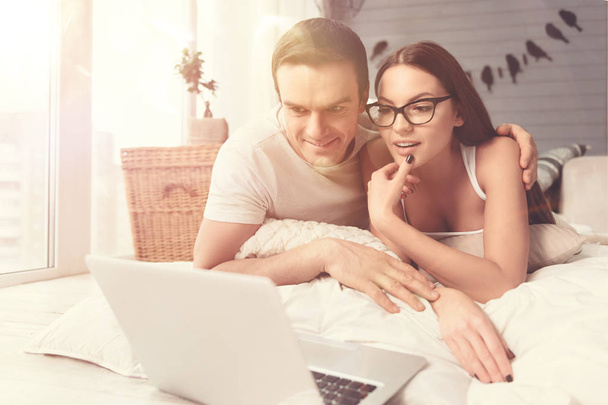 Emotional relaxed couple watching a movie in bed - Foto, immagini
