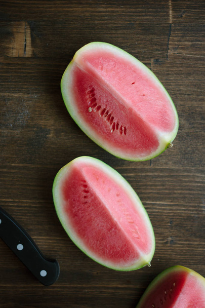 Small watermelon, piecies of delicious ripe watermelon on wooden board - Фото, изображение