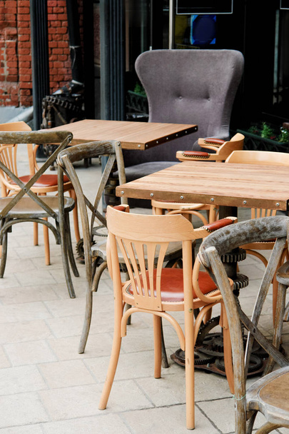 Καρέκλες και τραπέζια στην καλοκαιρινή βεράντα σε υπαίθριο καφέ - Φωτογραφία, εικόνα