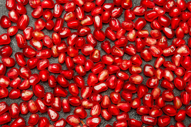 Pomegranate seeds close-up on dark concrete background - Фото, изображение