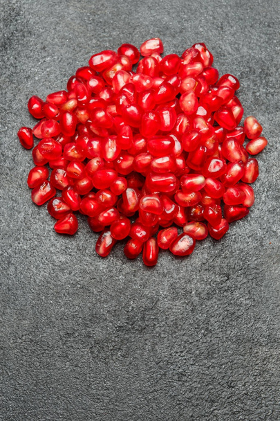 Pomegranate seeds close-up on dark concrete background - Zdjęcie, obraz