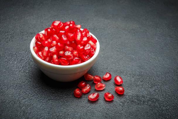 Pomegranate seeds close-up on dark concrete background - Фото, зображення