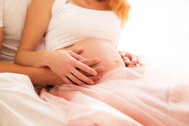 δύο ζεύγη χέρια στο γυμνός κοιλιά της εγκύου γυναίκας - Φωτογραφία, εικόνα