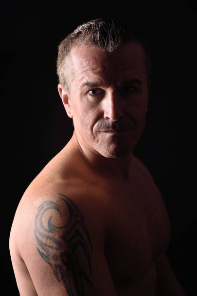портрет человека с татуировкой и черным фоном
 - Фото, изображение