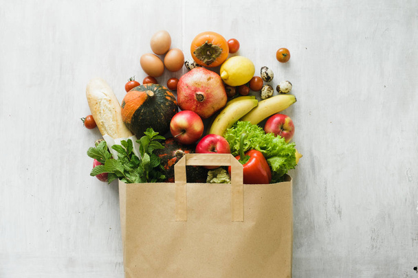 Paper bag of different health food on white wooden background. Top view. Flat lay - Foto, immagini