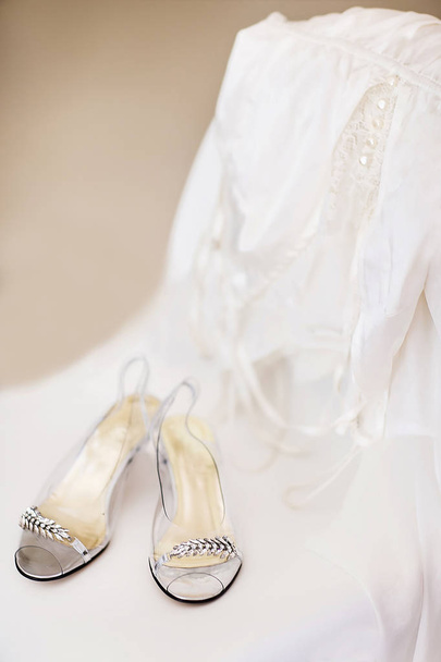 Zapatos de boda y bata en la silla blanca
 - Foto, Imagen