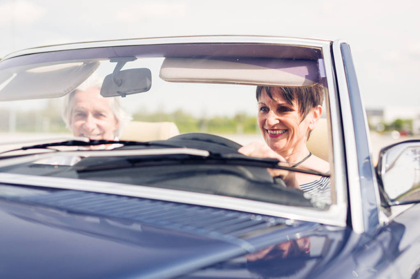 Senior Couple Driving A Convertible Classic Car - Фото, изображение