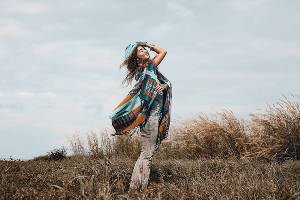 cheerful boho woman wearing poncho on field - Fotografie, Obrázek