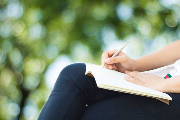 kobieta siedzi i pisania na notebook w parku - Zdjęcie, obraz