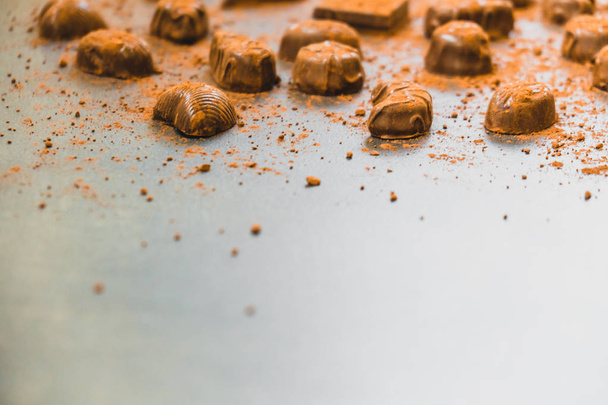 Şekerli tatlı koyu çikolata parçaları ve siyah taş zemin üzerine kakao tozu - Fotoğraf, Görsel