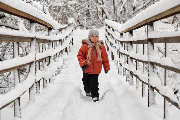 Veselý chlapeček jezdí v zimě na mostě. - Fotografie, Obrázek