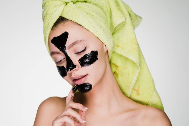 atraktivní mladá dívka chce čistou pokožku na tváři, použita černá čistící maska na obličej - Fotografie, Obrázek