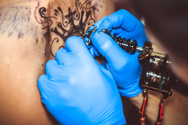 mester tetoválás a nő a hátán - Fotó, kép