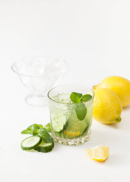 Drink of chopped cucumber, mint and lemon on white background - Foto, imagen