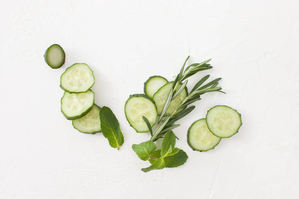 Background of sliced cucumbers with sprigs of greenery - Φωτογραφία, εικόνα