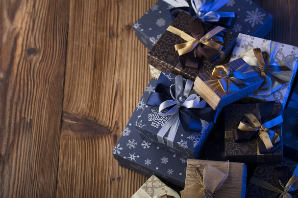 Presents in blue and gold aesthetics, rustic wooden table. Place for text. - Photo, Image