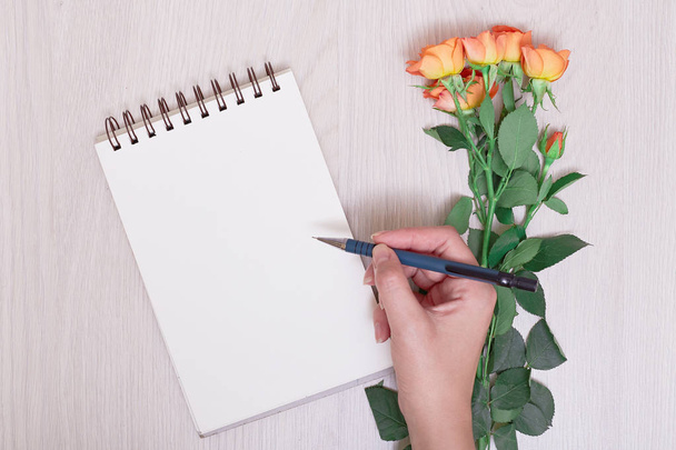 beyaz boş defter ve kalem ve defter kağıt, kalem ve kuru çiçekler arka plan üzerinde yazma el - Fotoğraf, Görsel