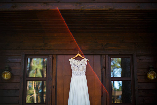 Vestido de novia colgado en la puerta de madera
 - Foto, Imagen